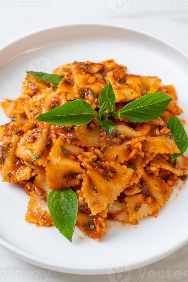 Farfalle con basilico e aglio in salsa di pomodoro - salsa italiana foto