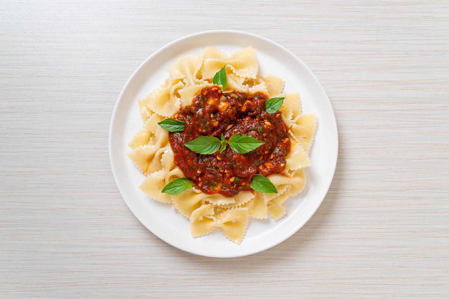 Farfalle con basilico e aglio in salsa di pomodoro - salsa italiana foto