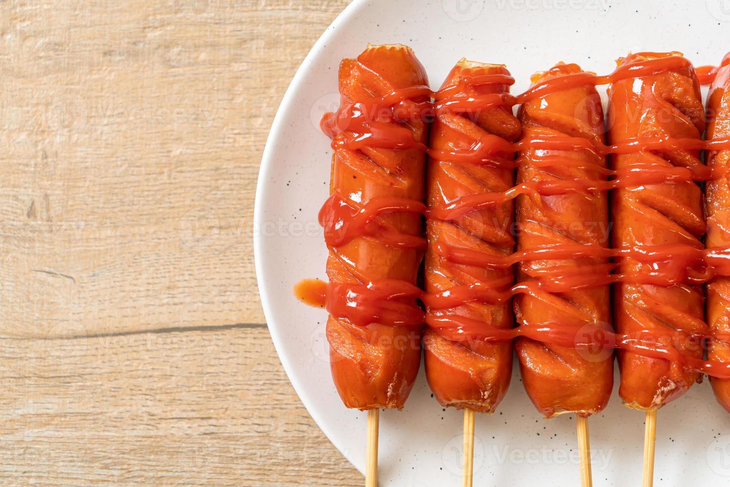 spiedino di salsiccia fritta con ketchup su un piatto bianco foto