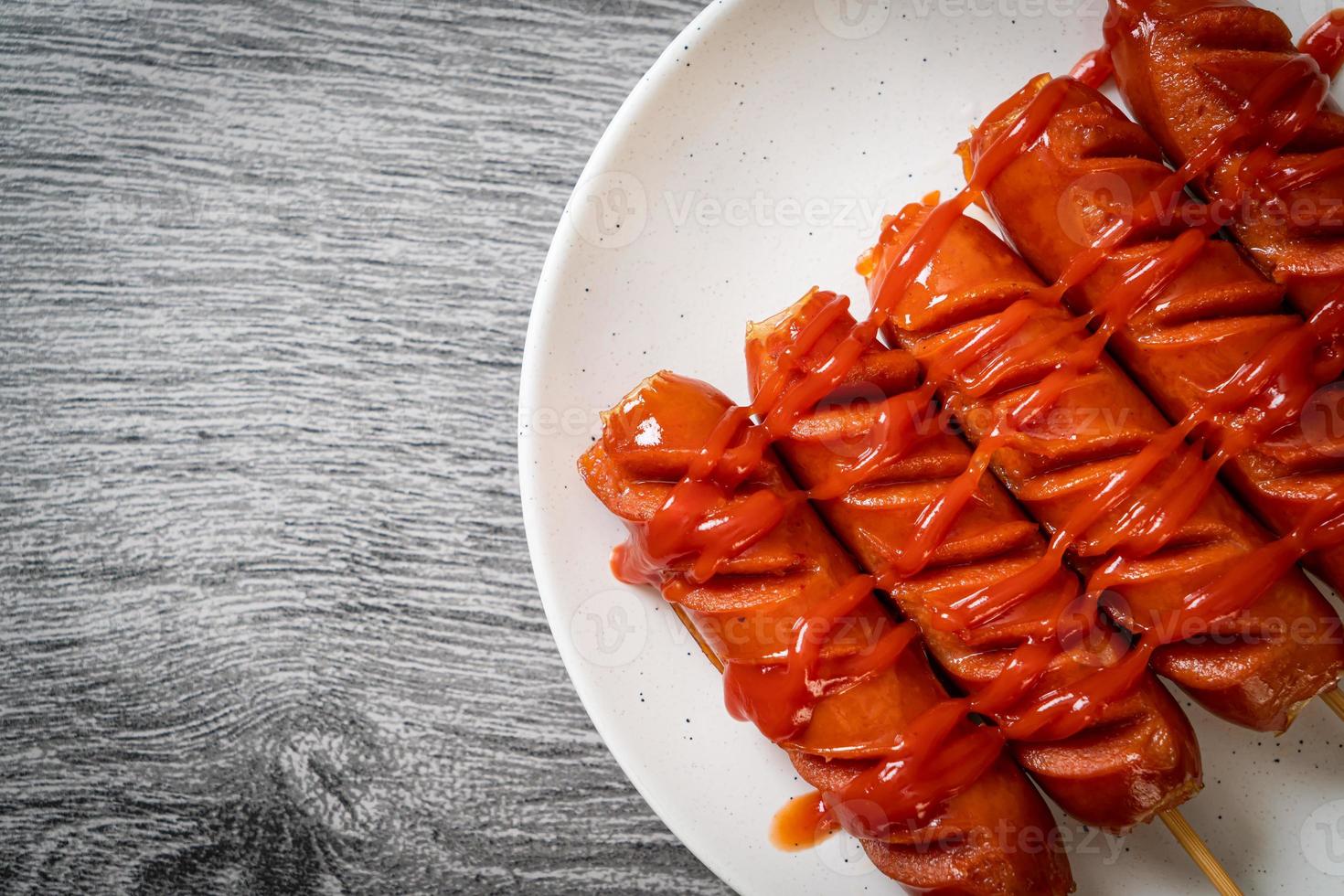 spiedino di salsiccia fritta con ketchup su un piatto bianco foto