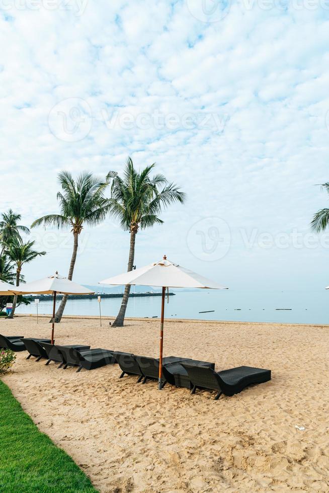 sedia a sdraio vuota con palme sulla spiaggia con sfondo mare sea foto