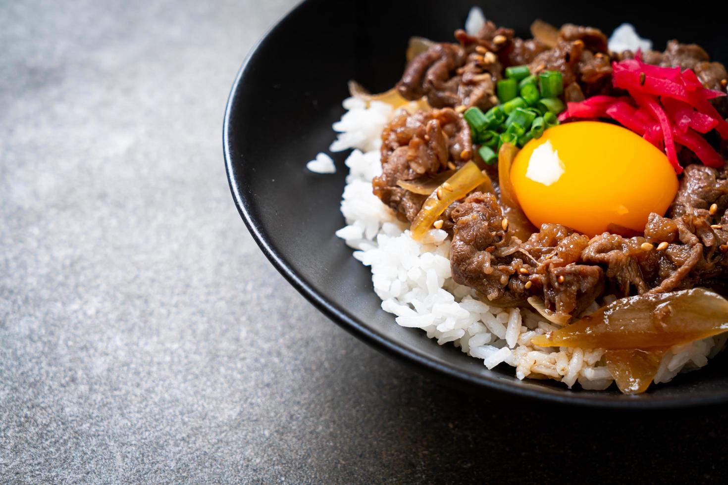 manzo affettato su riso condito con uovo o gyudon - stile giapponese foto