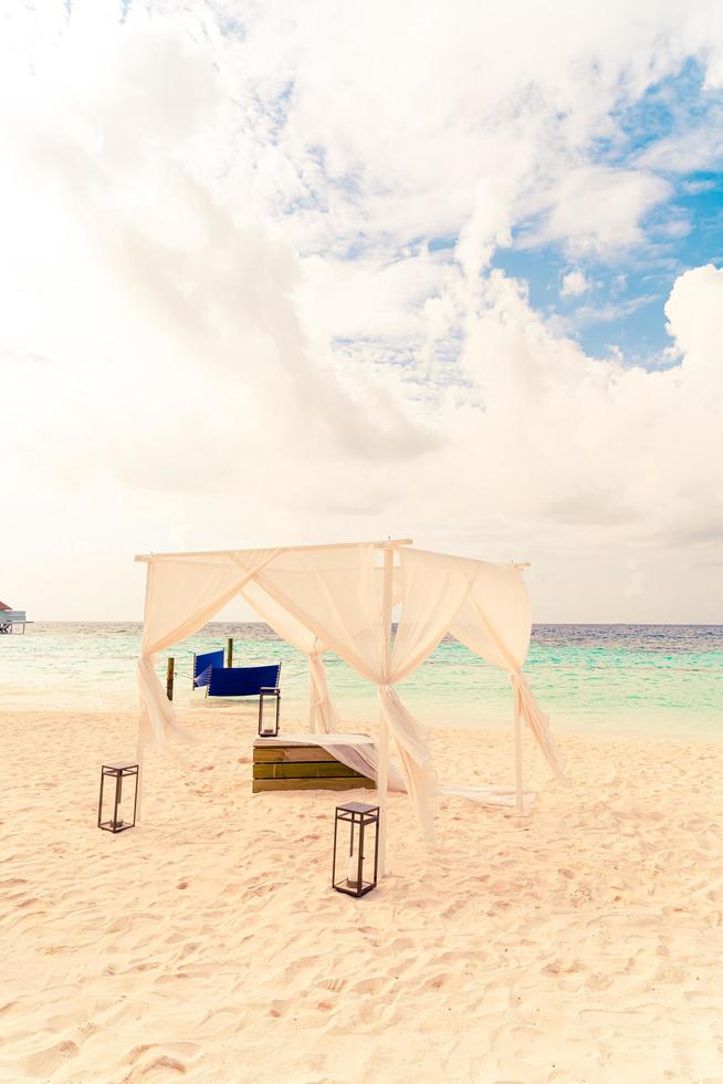 arco nuziale sulla spiaggia con resort tropicale delle maldive e sfondo del mare foto