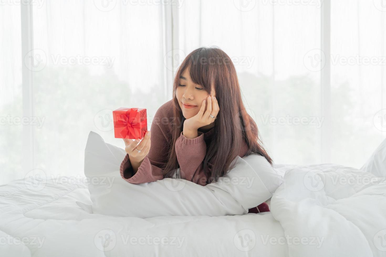 donna asiatica felice di ricevere una confezione regalo o un regalo foto
