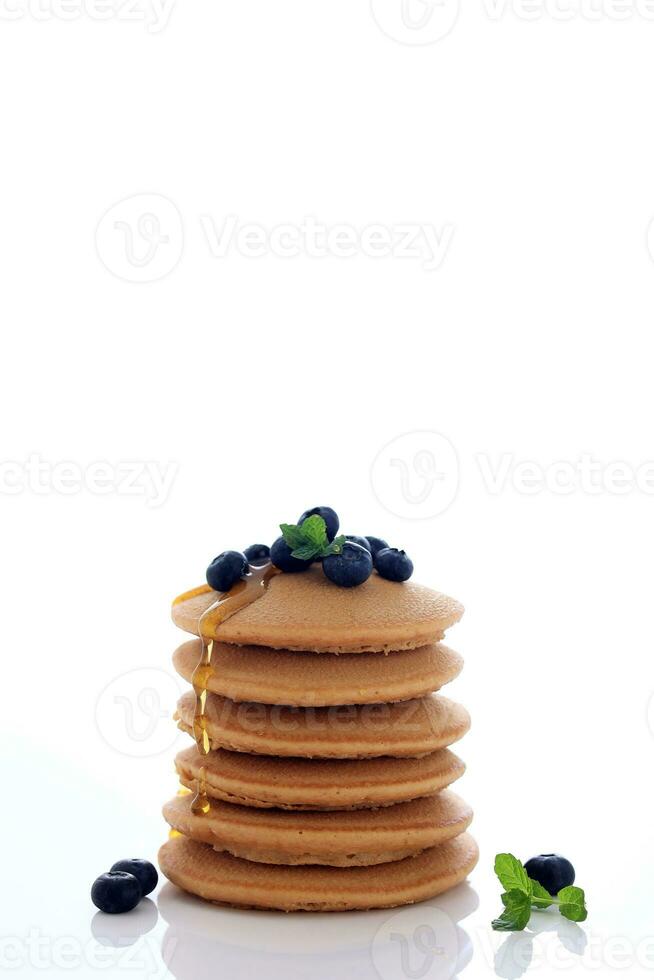 pila di delizioso Pancakes con fresco mirtilli, menta foglia, e acero sciroppo foto