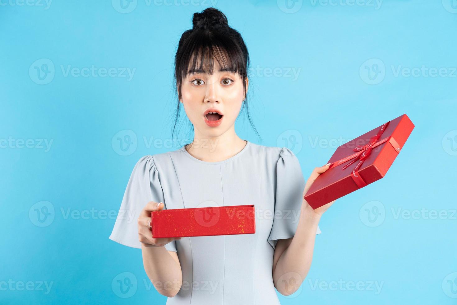 bella donna asiatica su sfondo blu con scatole regalo foto