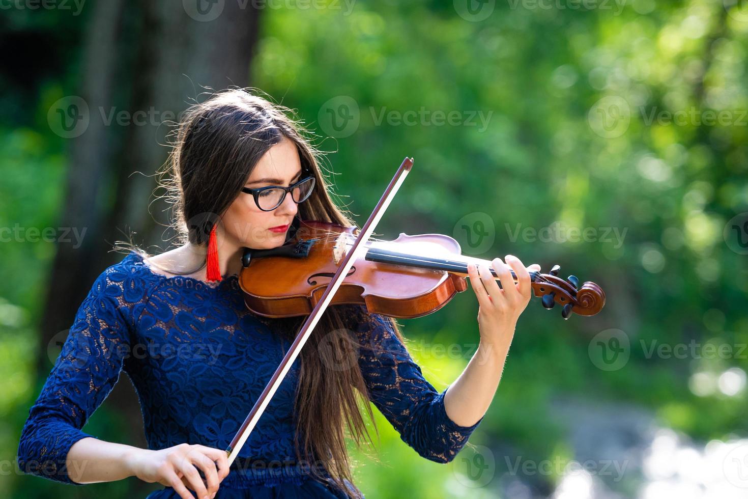 giovane donna che suona il violino al parco. profondità di campo ridotta - immagine foto