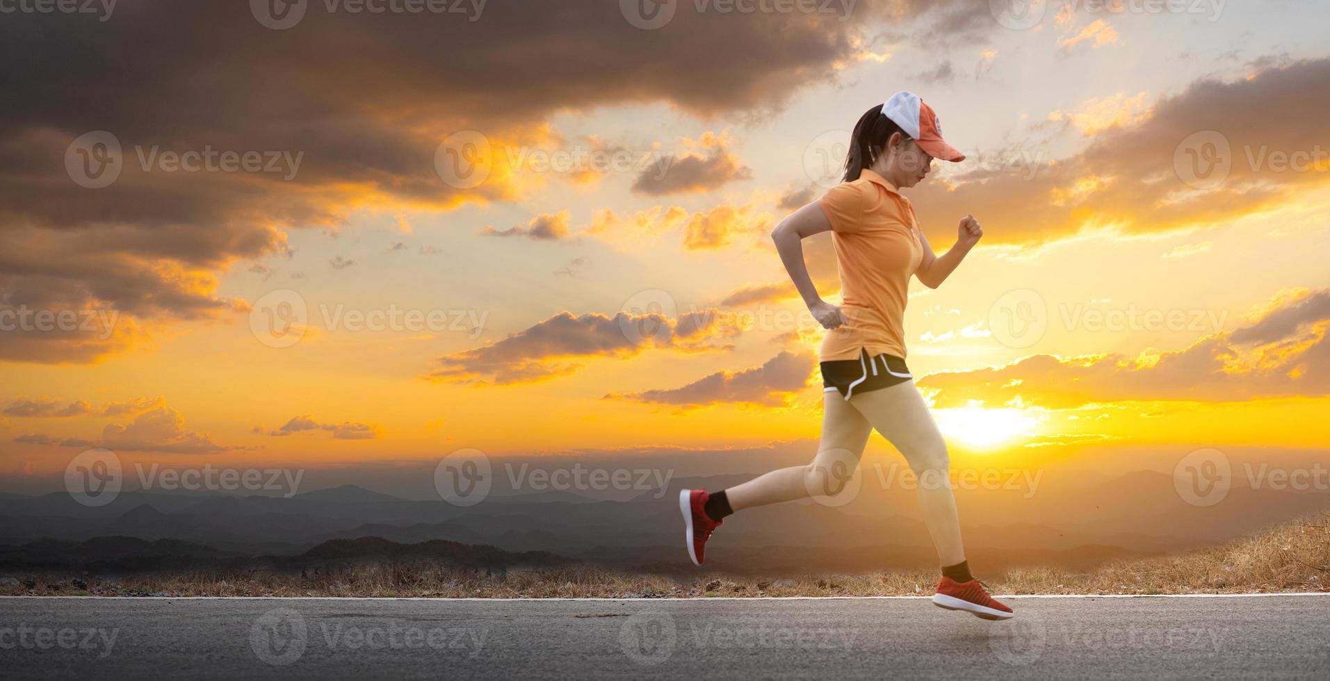 Asia giovane donna runner in esecuzione su strada asfaltata al sole sta cadendo dietro lo sfondo della montagna foto