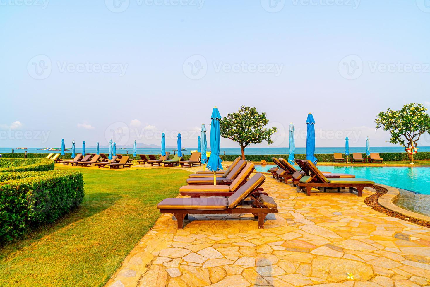 sedie piscine o lettini e ombrelloni intorno alla piscina con sfondo mare - vacanze e concetto di vacanza vacation foto