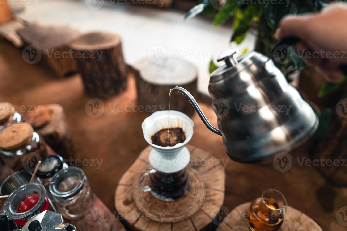 versando acqua calda su un caffè americano foto