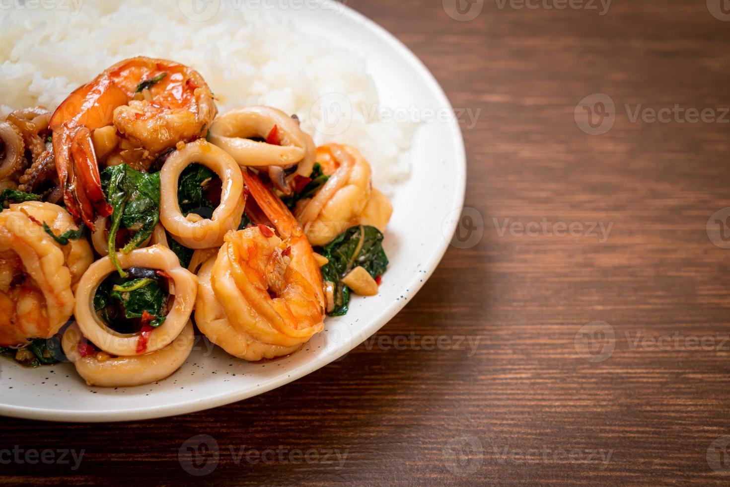 riso e frutti di mare saltati in padella di gamberi e calamari con basilico thai - stile asiatico foto