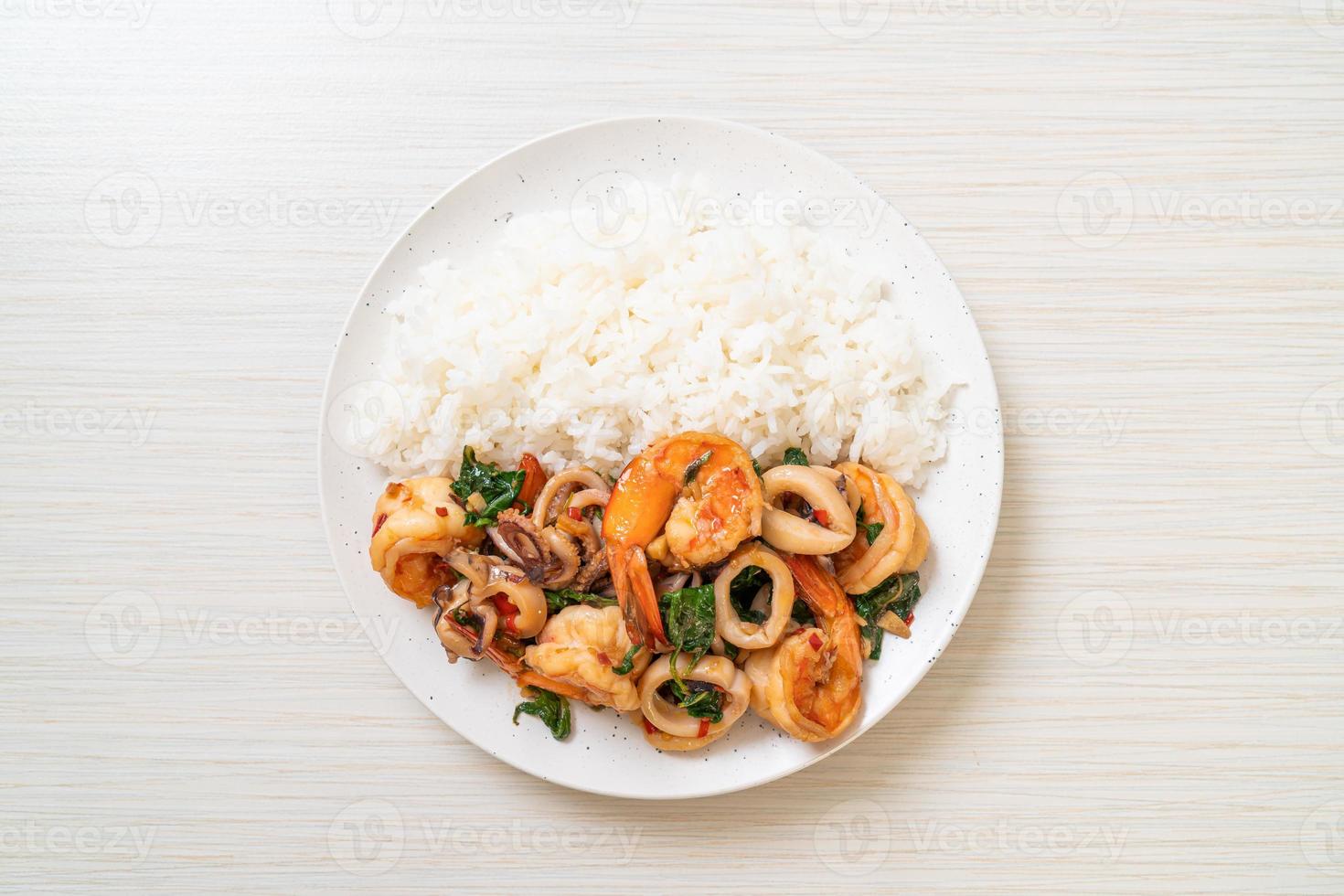 riso e frutti di mare saltati in padella di gamberi e calamari con basilico thai - stile asiatico foto