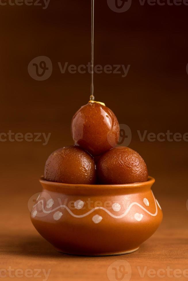 gulab jamun in vaso di terracotta. dessert indiano o piatto dolce foto