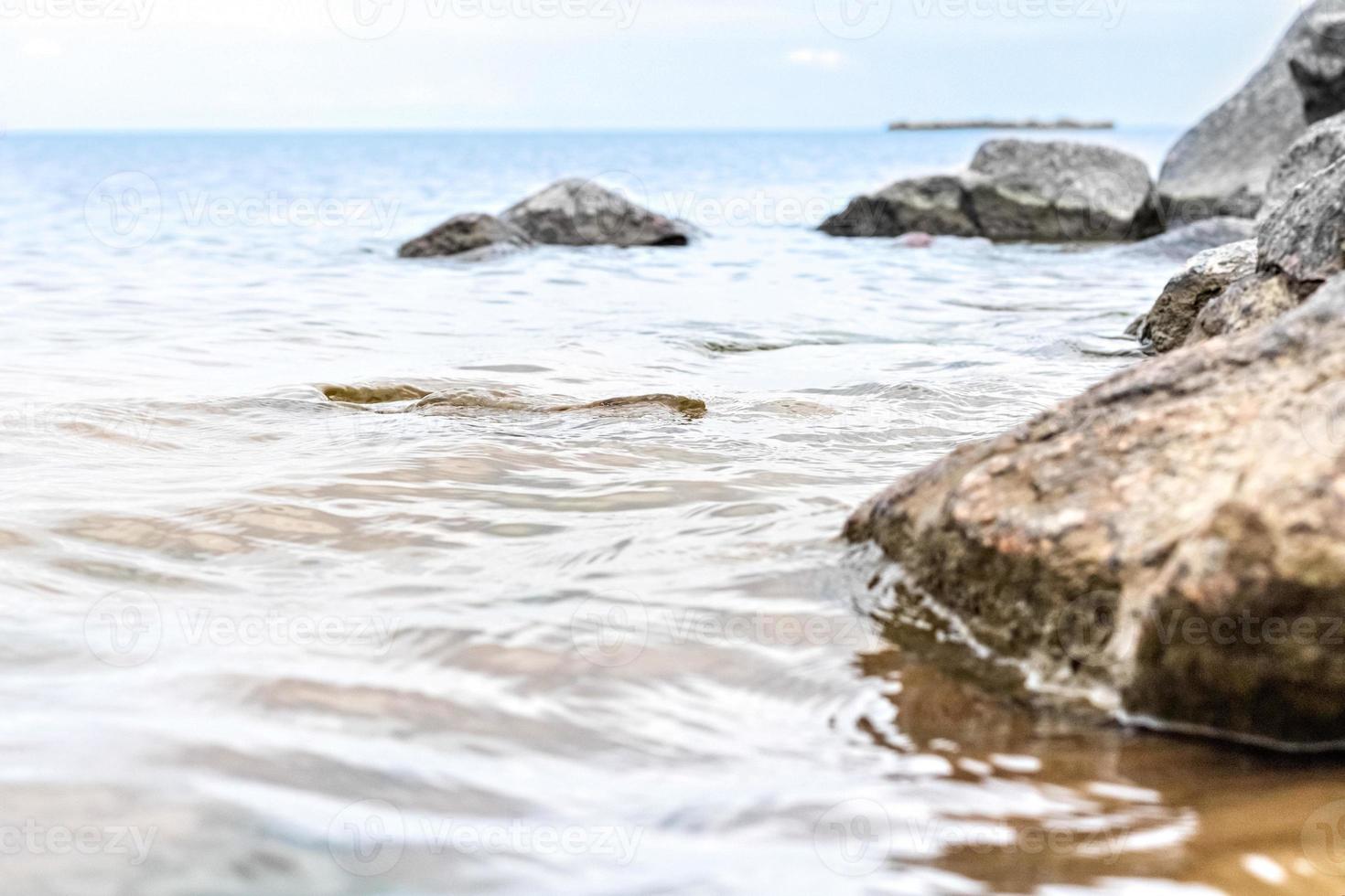 pietre di granito nell'acqua sulla riva del golfo di finlandia. foto