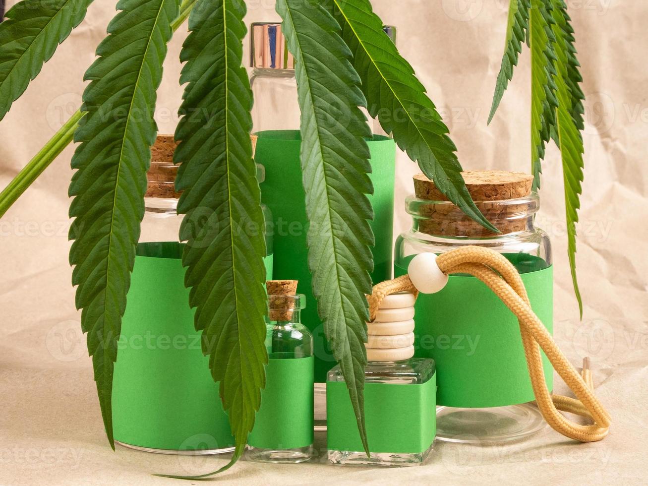 cosmetici naturali con cannabis e bottiglie verdi e foglie di marijuana foto
