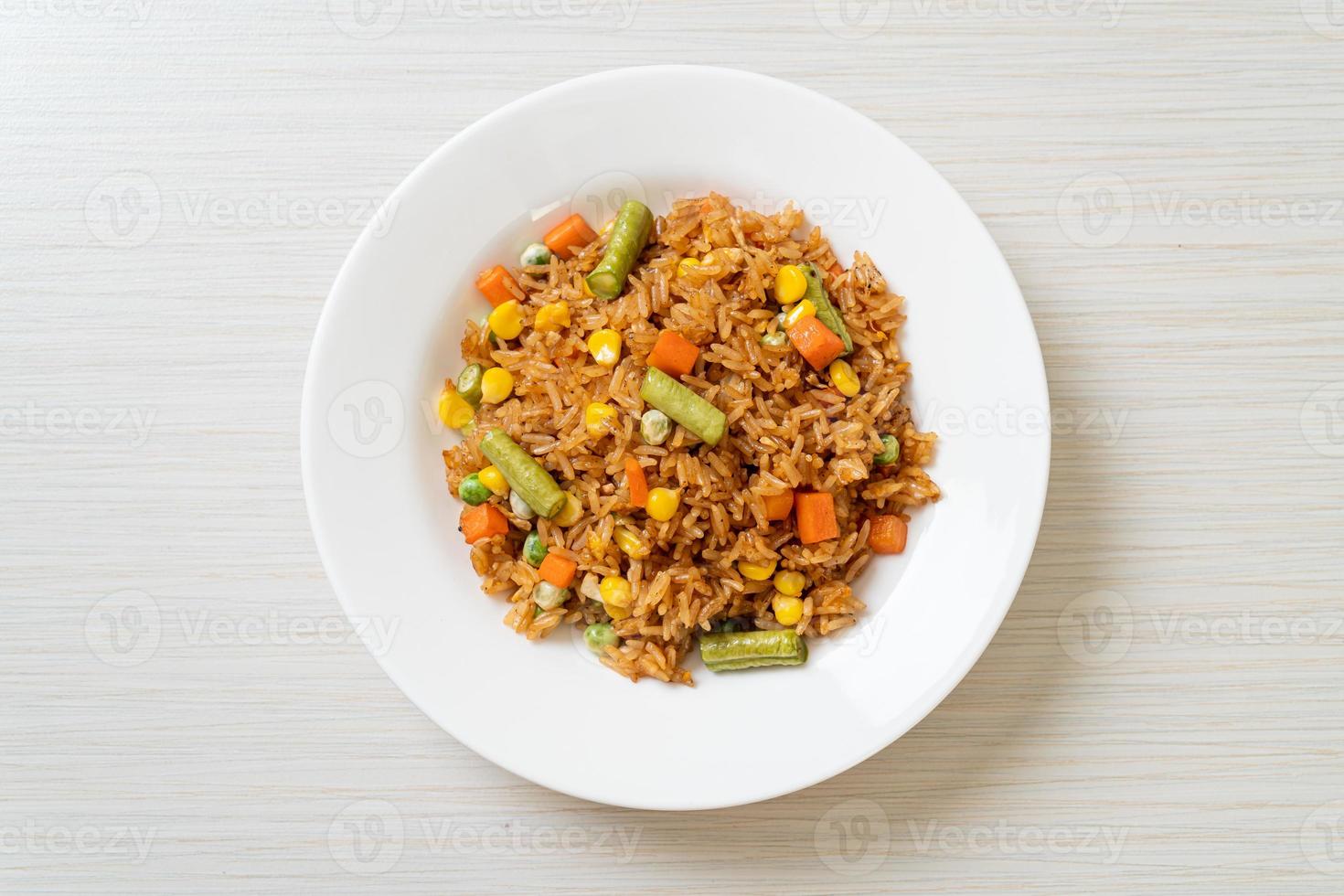 riso fritto con piselli, carote e mais - stile alimentare vegetariano e sano foto