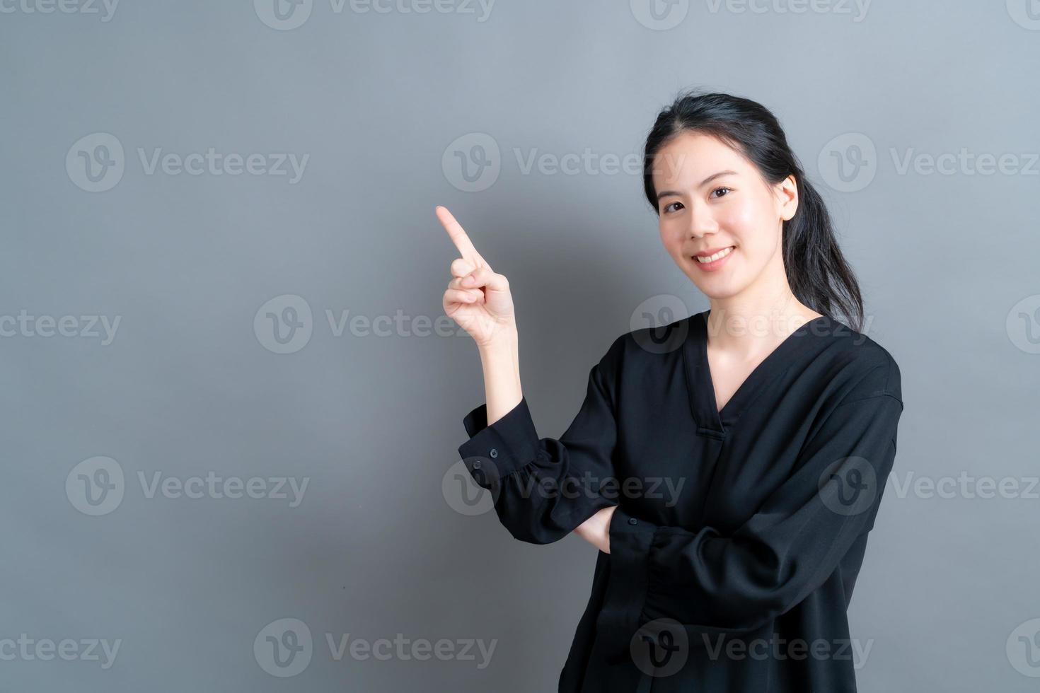 donna asiatica con la mano che presenta sul lato foto