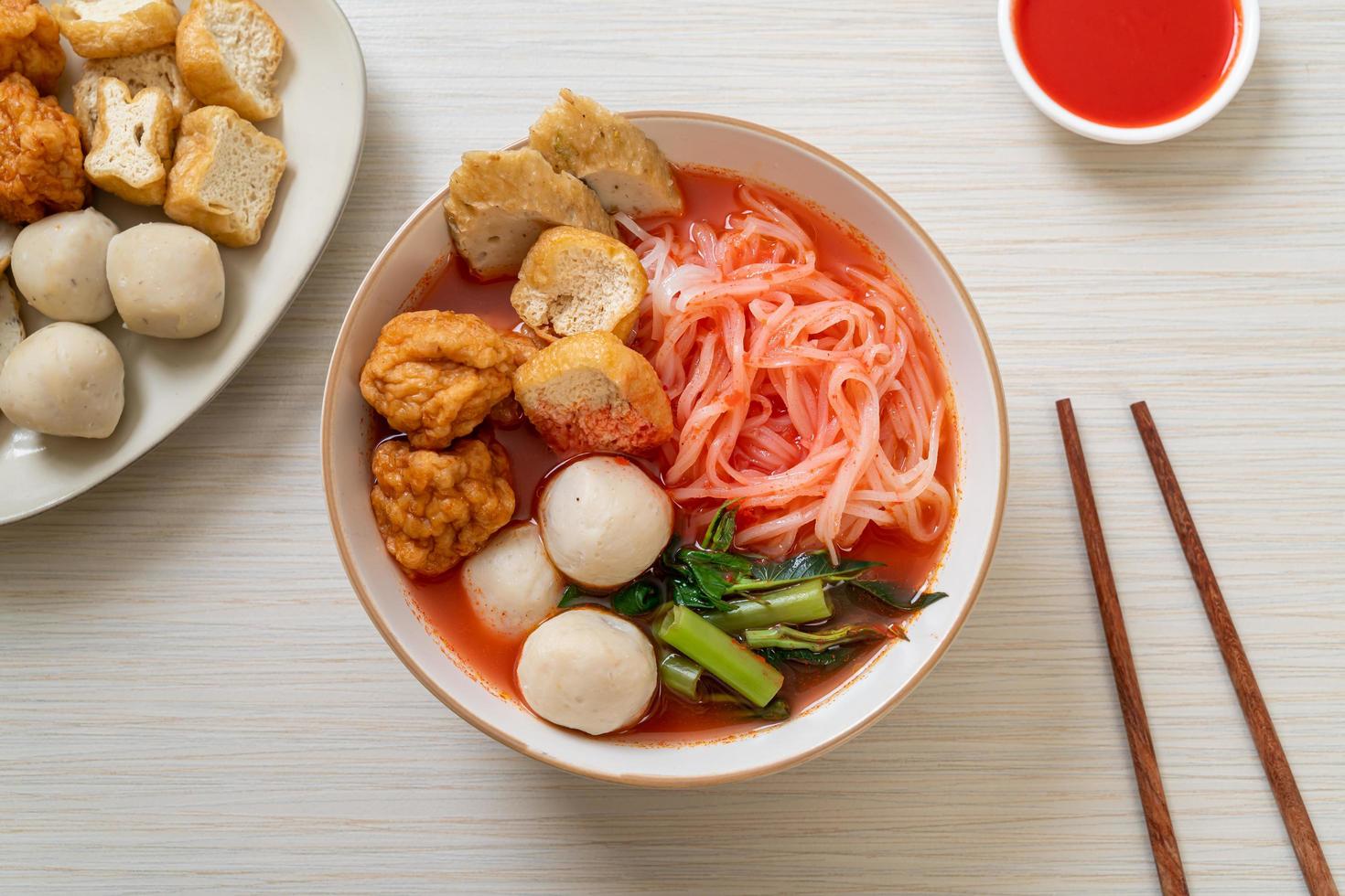 piccoli spaghetti di riso piatti con polpette di pesce e polpette di gamberi in zuppa rosa, yen ta quattro o yen ta fo - stile asiatico foto