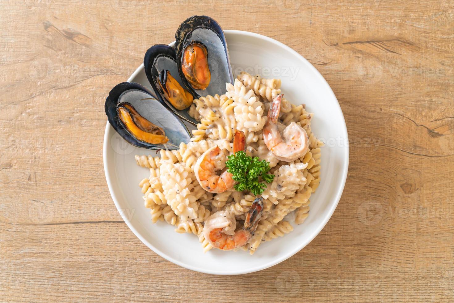 pasta a spirale salsa di crema di funghi con frutti di mare - stile italiano foto