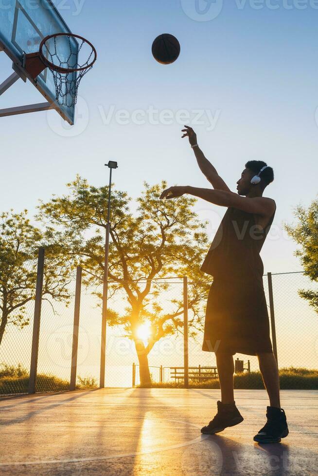 nero uomo fare gli sport, giocando pallacanestro su Alba, attivo stile di vita, soleggiato estate mattina foto