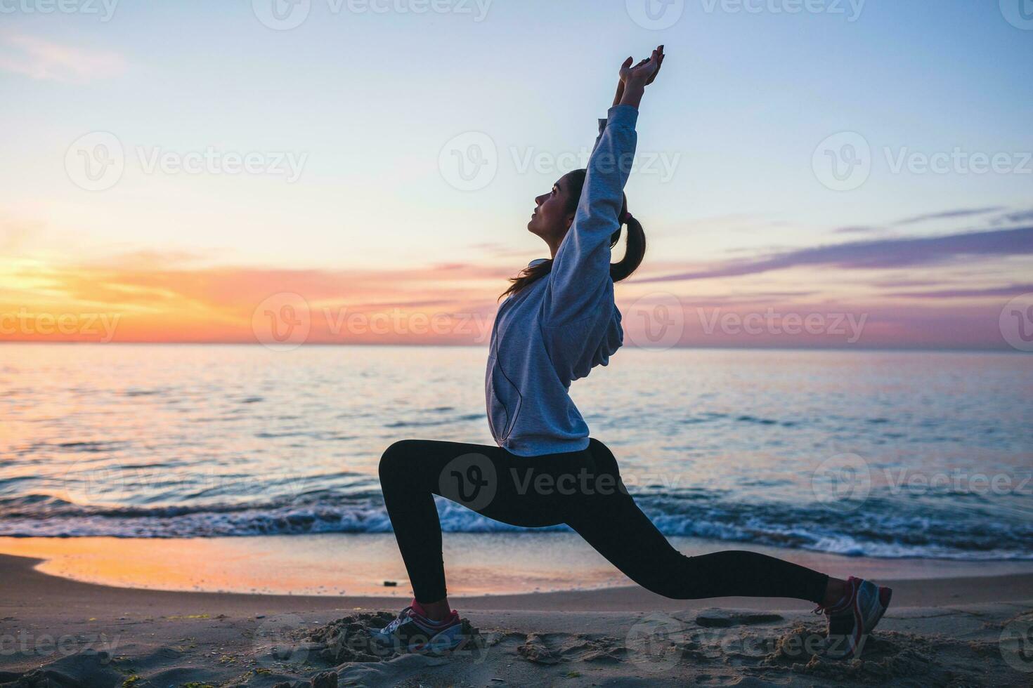 giovane donna fare sport esercizi su Alba spiaggia nel mattina foto