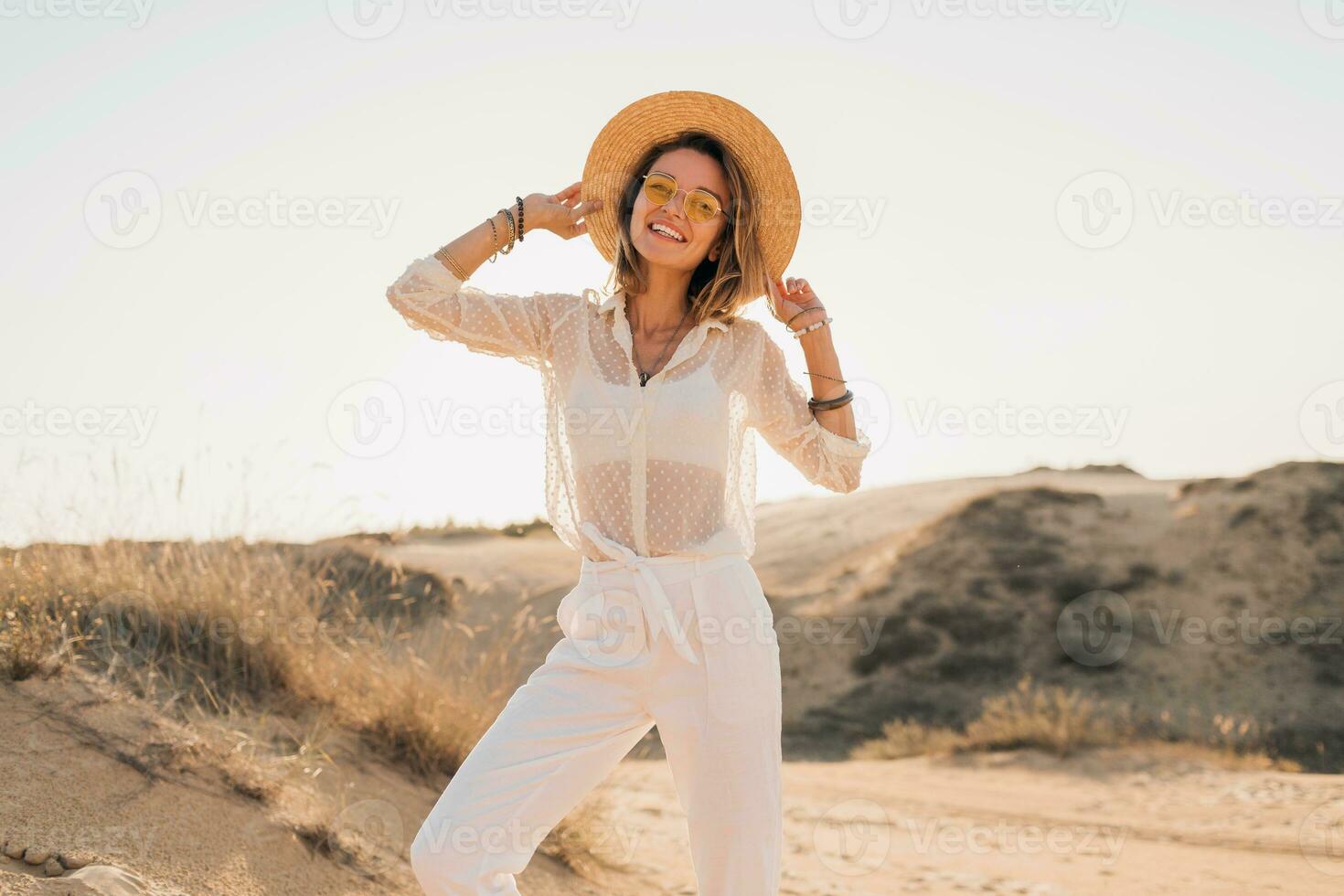 elegante bellissimo spensierato contento donna a piedi nel deserto sabbia vestito nel bianca attrezzatura foto