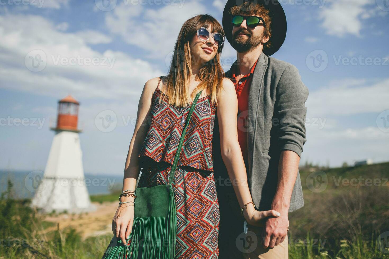 sorridente Tenere mani giovane fricchettone coppia indie stile nel amore a piedi nel campagna foto