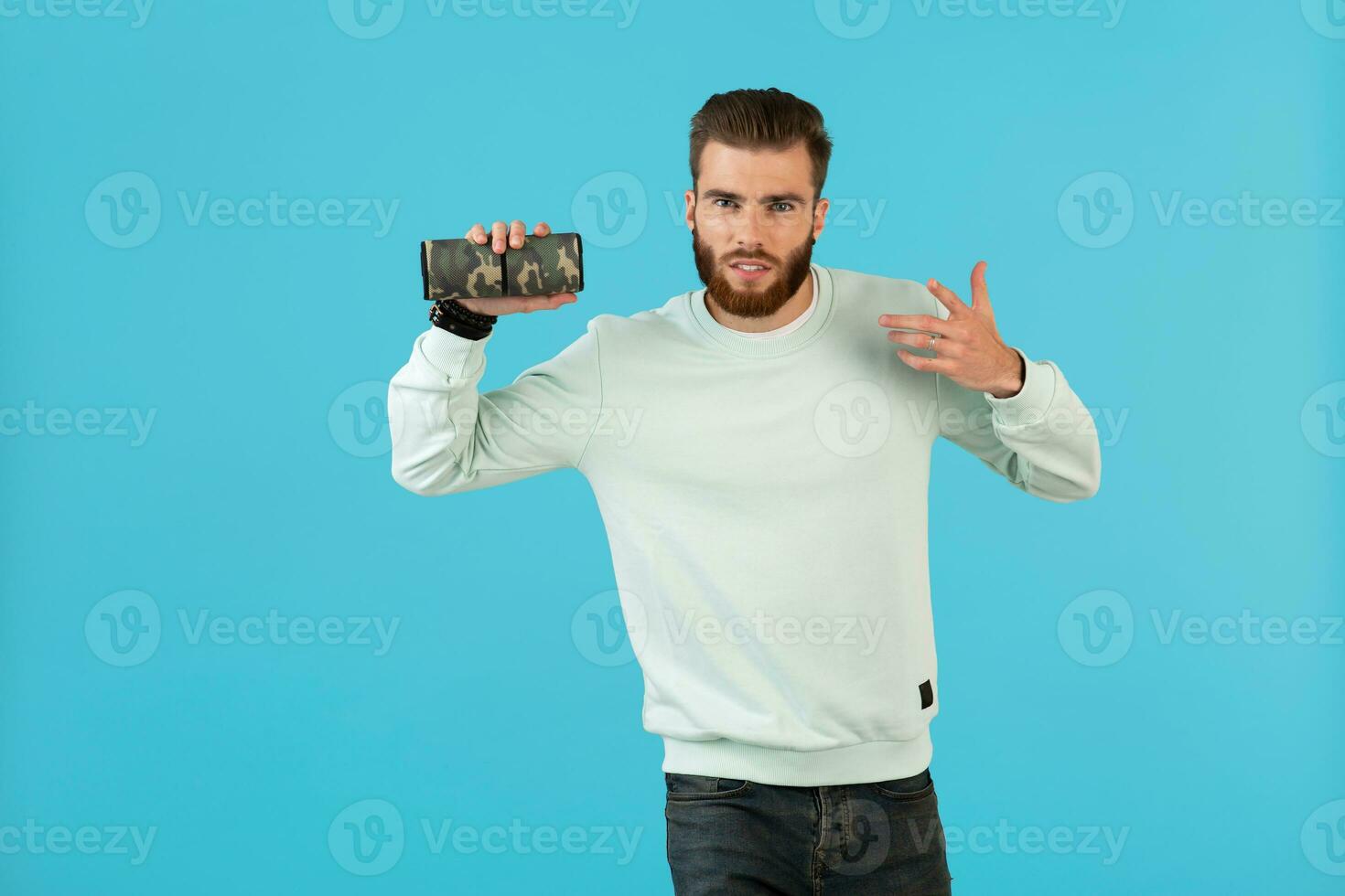 elegante giovane uomo Tenere senza fili altoparlante foto