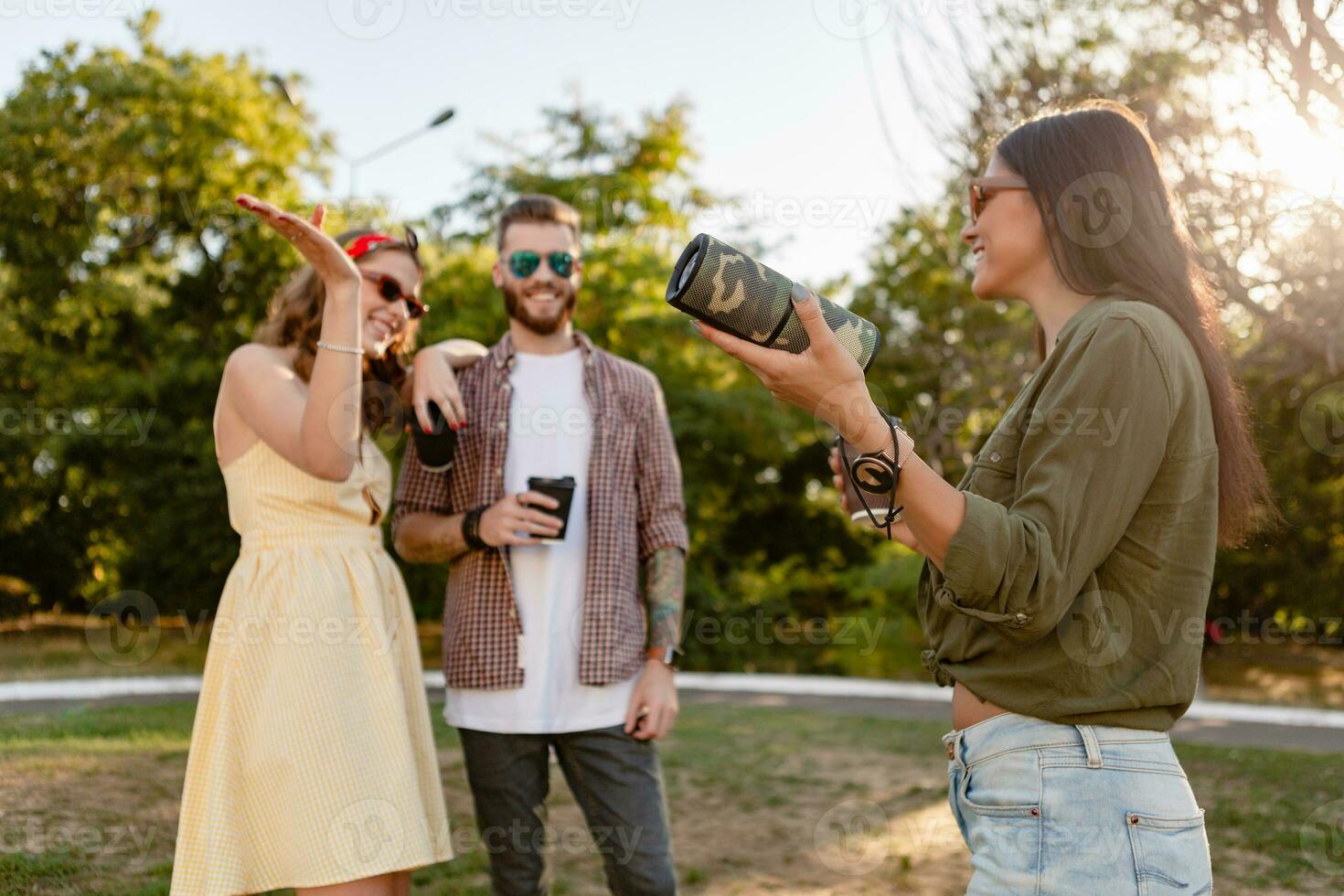 azienda di amici avendo divertimento insieme nel parco ascoltando per musica foto