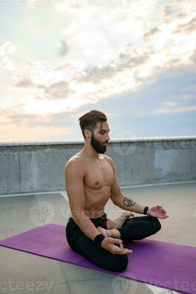 attraente bello uomo con atletico forte corpo fare mattina yoga dzen meditazione foto