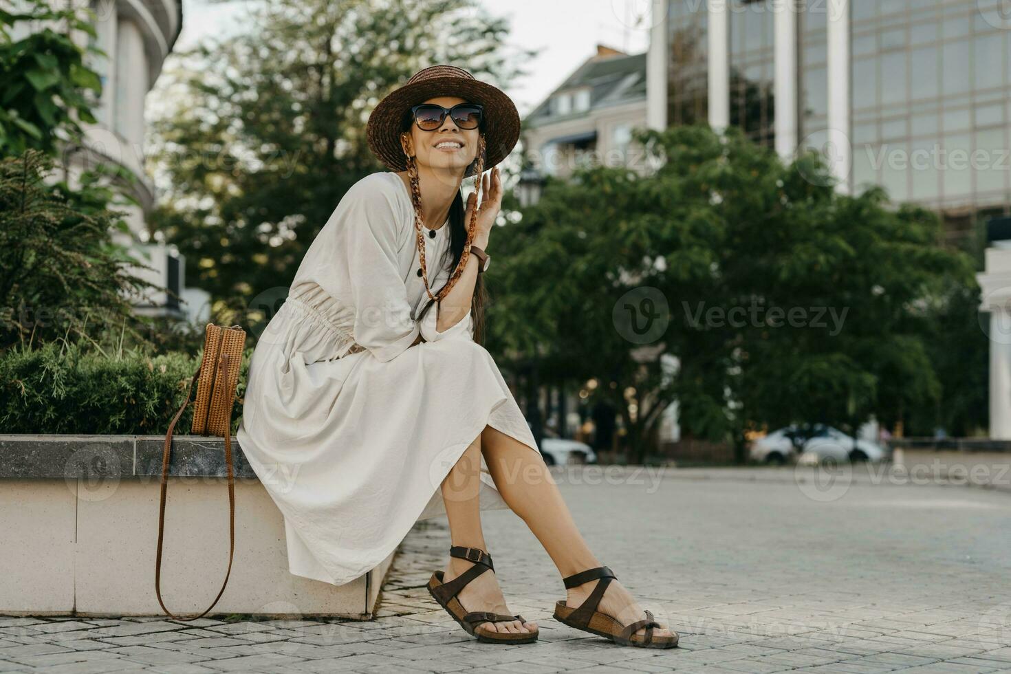 bellissimo donna a piedi nel strada su vacanza vestito nel bianca estate moda vestito foto