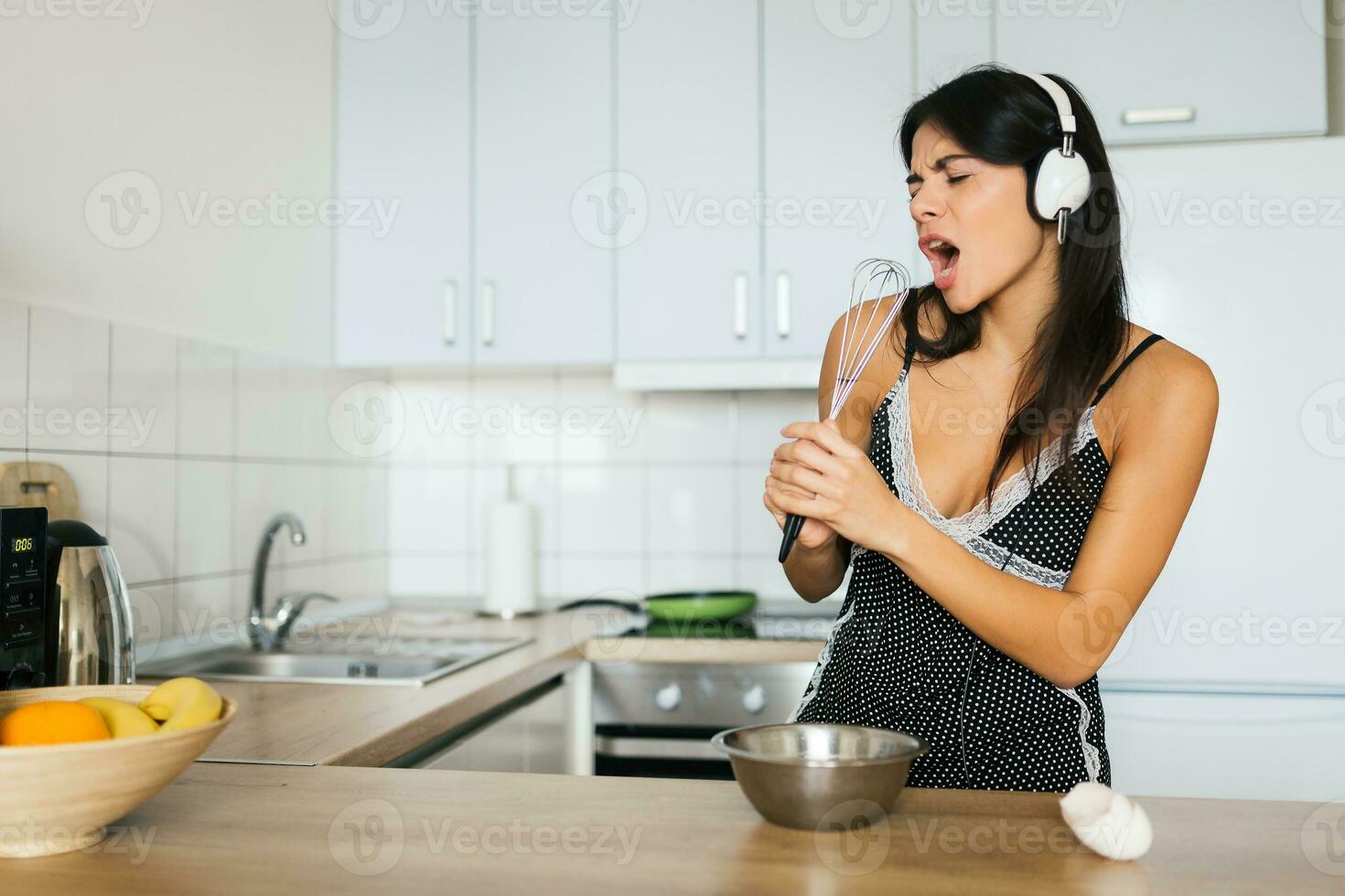attraente sorridente donna nel pigiama avendo prima colazione nel cucina foto