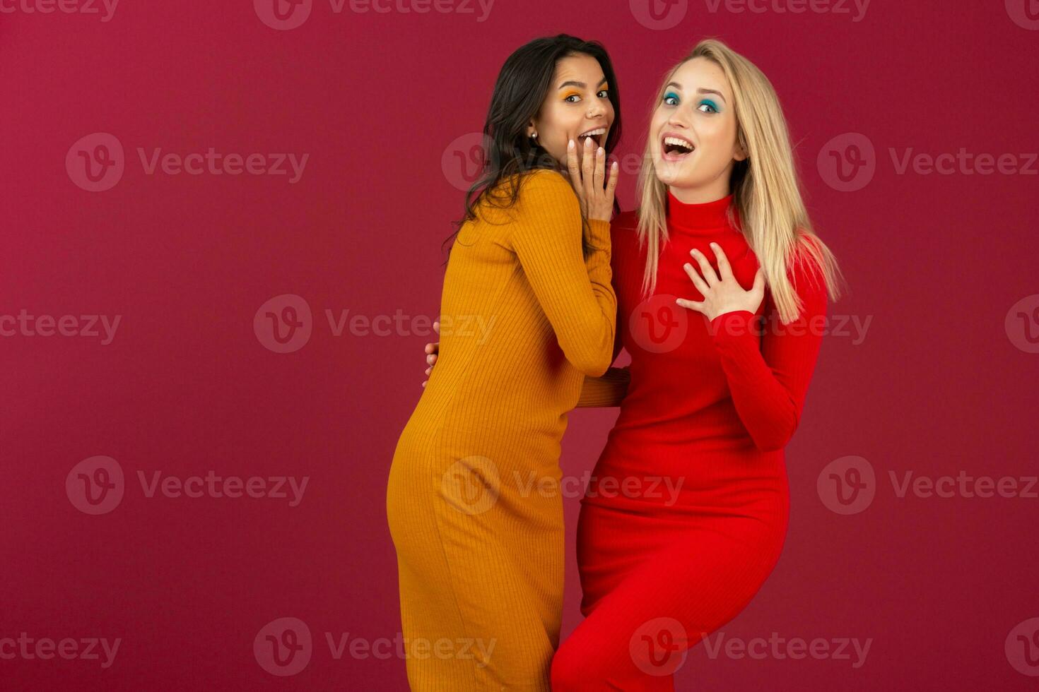 contento sorridente bella elegante donne nel giallo e rosso autunno inverno moda a maglia vestito in posa isolato su rosso studio sfondo foto