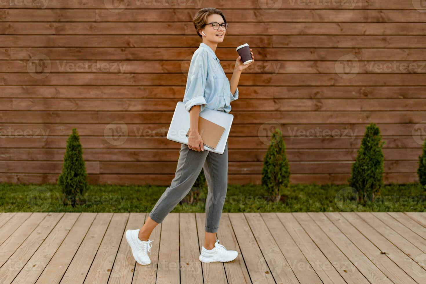 giovane bella donna seduta con il computer portatile nel moderno parco strada foto