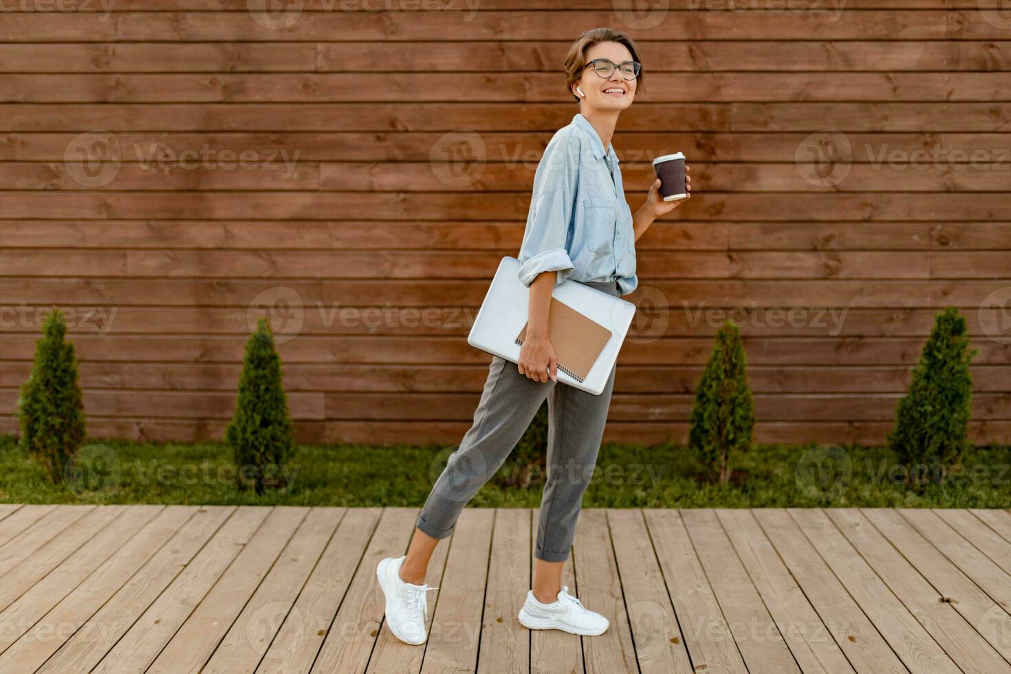 giovane bella donna seduta con il computer portatile nel moderno parco strada foto