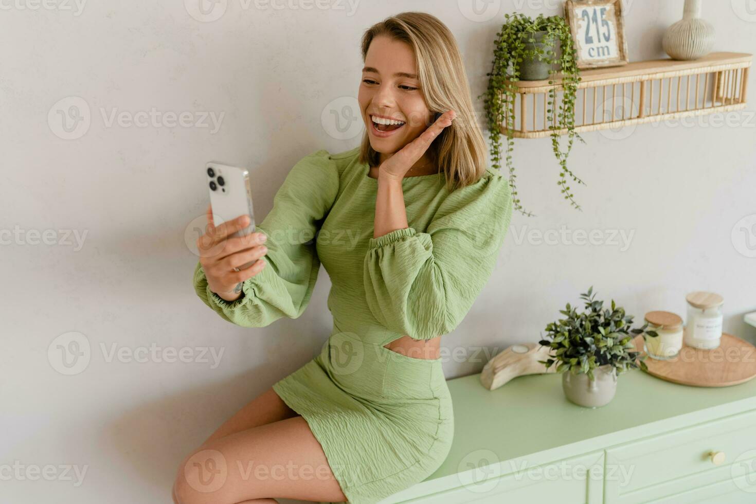 giovane elegante sorridente donna nel verde estate vestito nel moderno interno appartamento casa foto