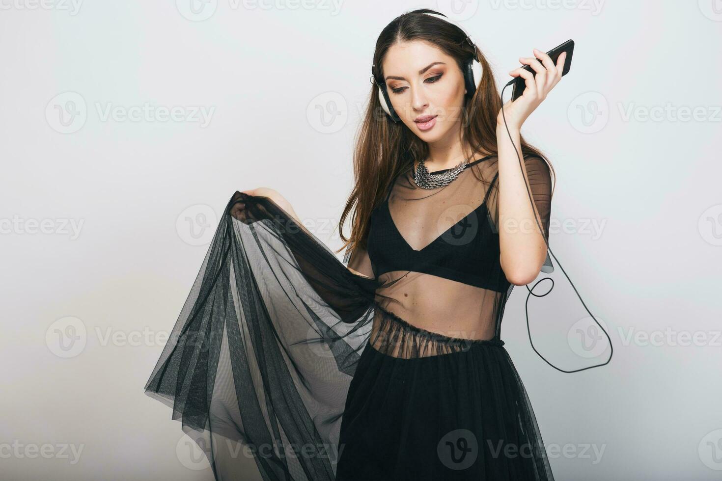 bellissimo elegante donna isolato nel nero completo da uomo ascoltando per musica su cuffie danza foto