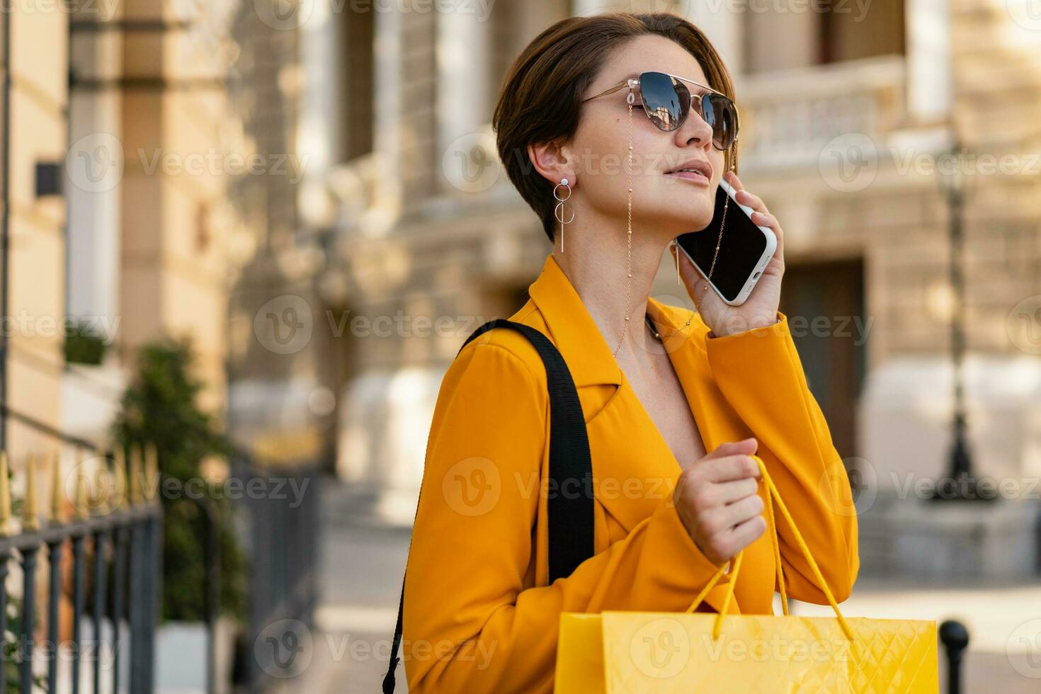 elegante elegante donna su shopping nel città strada indossare luminosa colorato giallo completo da uomo estate stile foto