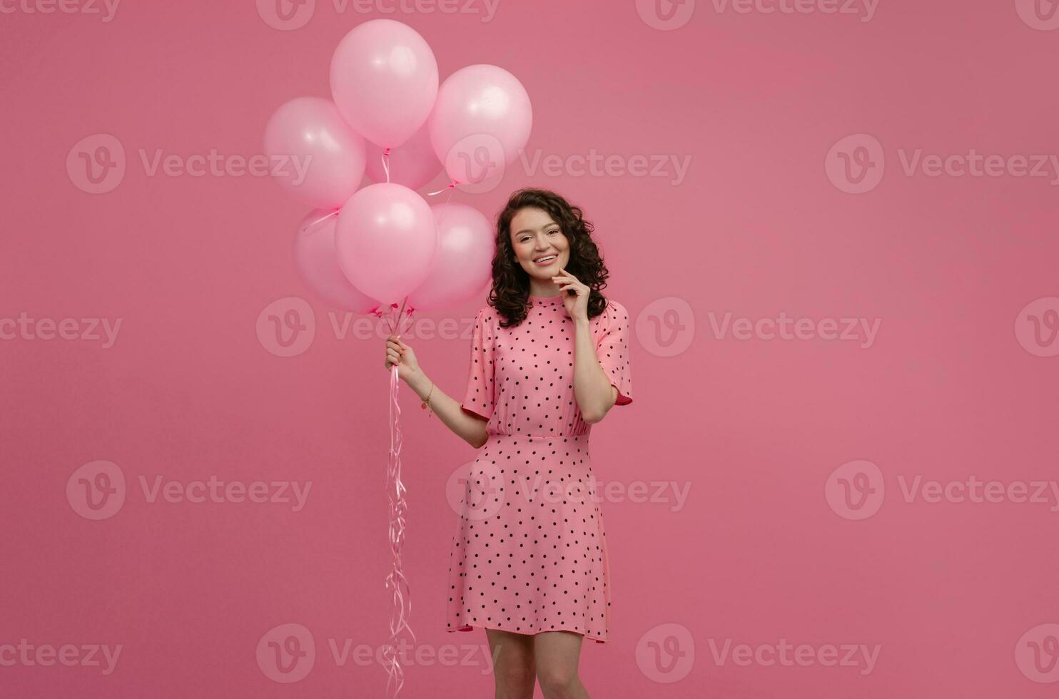 bella giovane donna in posa isolato su rosa studio sfondo con rosa aria baloons foto
