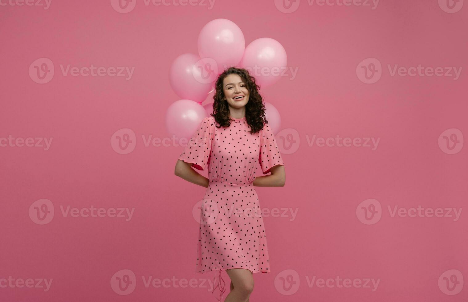 bella giovane donna in posa isolato su rosa studio sfondo con rosa aria baloons foto