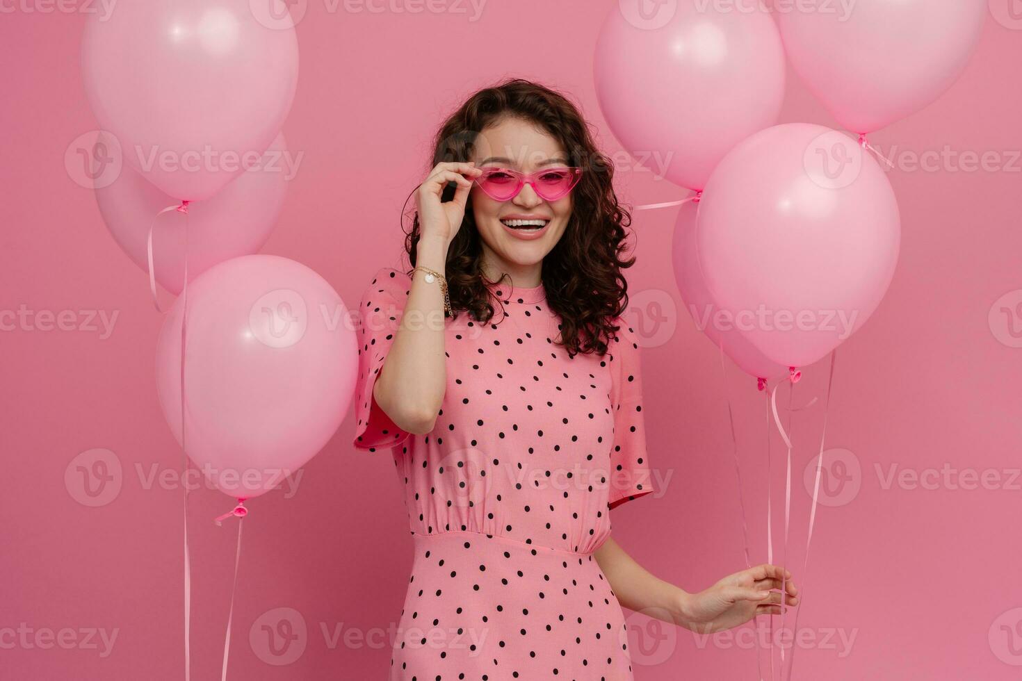 bella giovane donna in posa isolato su rosa studio sfondo con rosa aria baloons foto