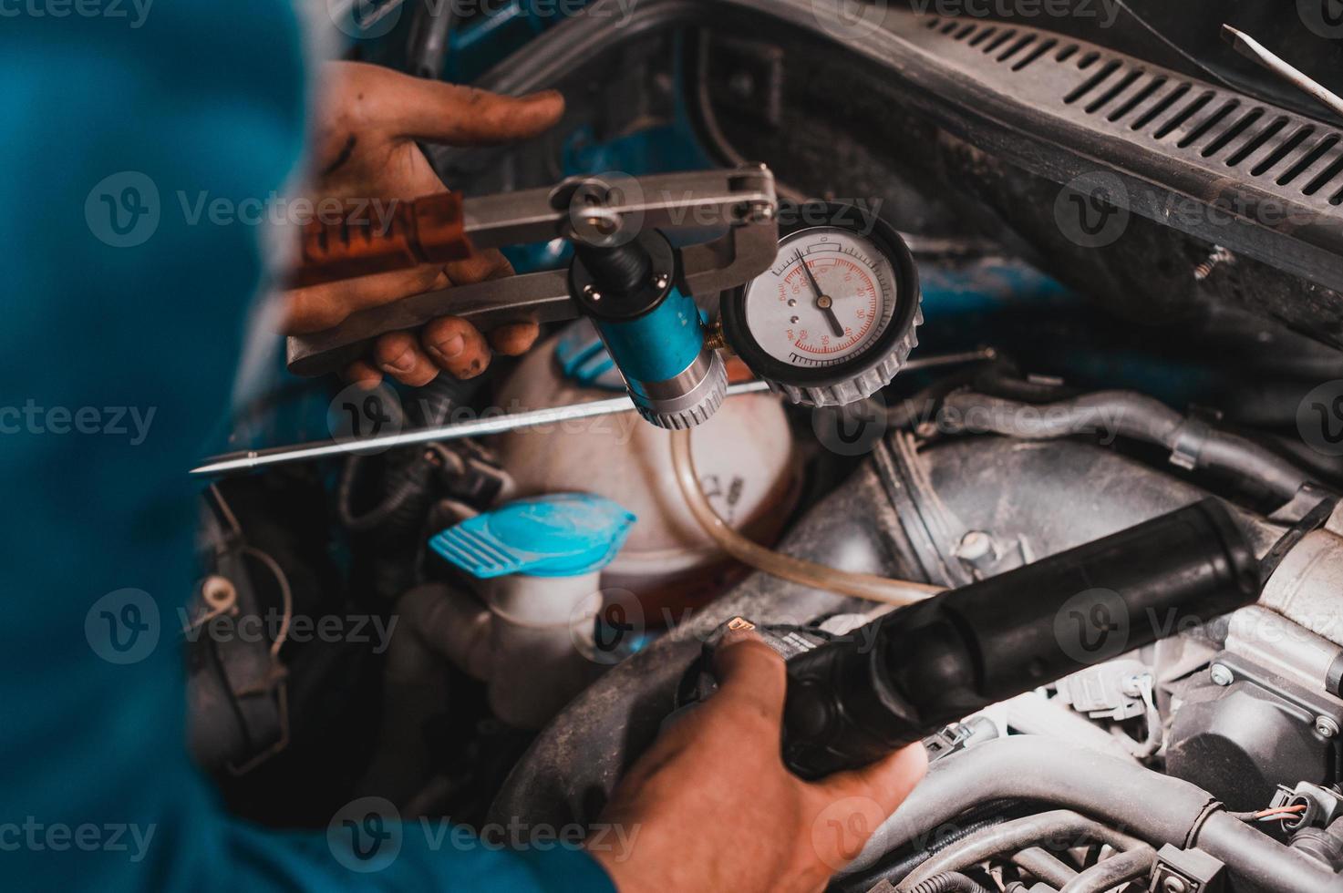 meccanico professionista che lavora in un servizio di auto, diagnostica computerizzata dello spazio del cofano nell'auto. foto