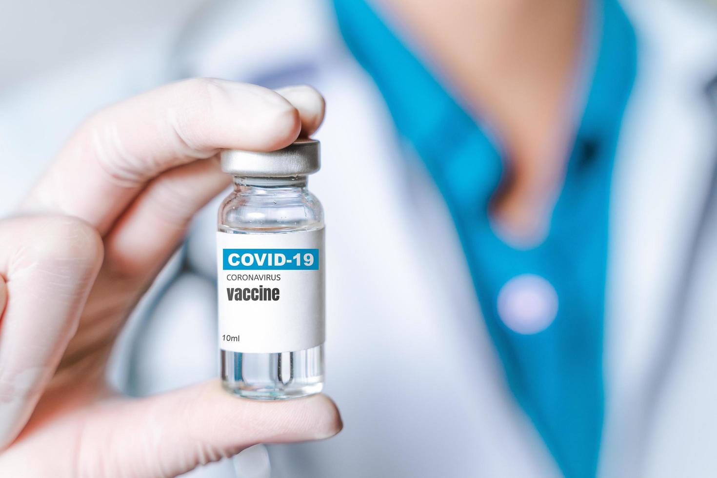 medico o scienziato in laboratorio che tiene un vaccino contro il coronavirus in una bottiglia di vetro. covid-19 concetto di trattamento del virus corona. foto