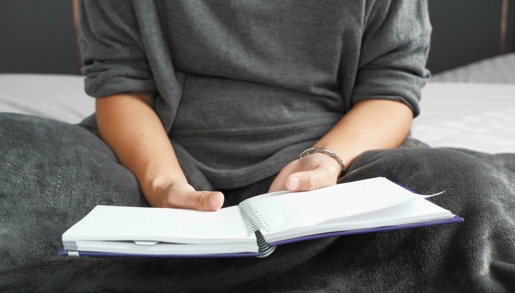 il mano di un' donna seduta e lettura un' libro adatto per fabbricazione infografica. foto