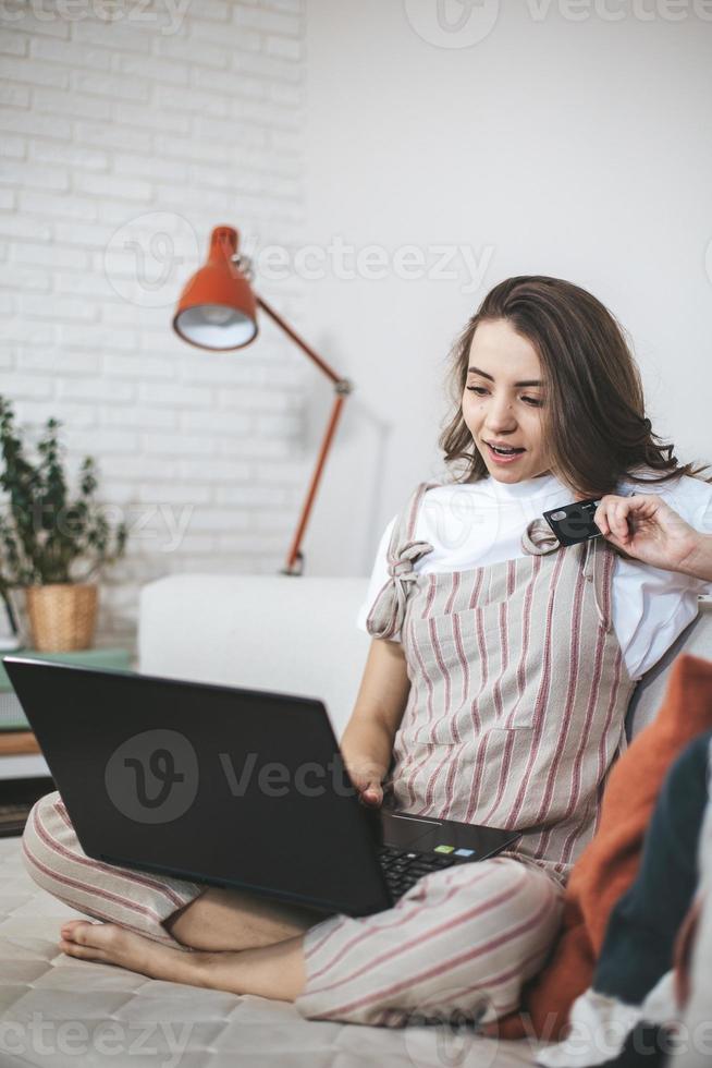 giovane donna millenaria che fa shopping online a casa. foto