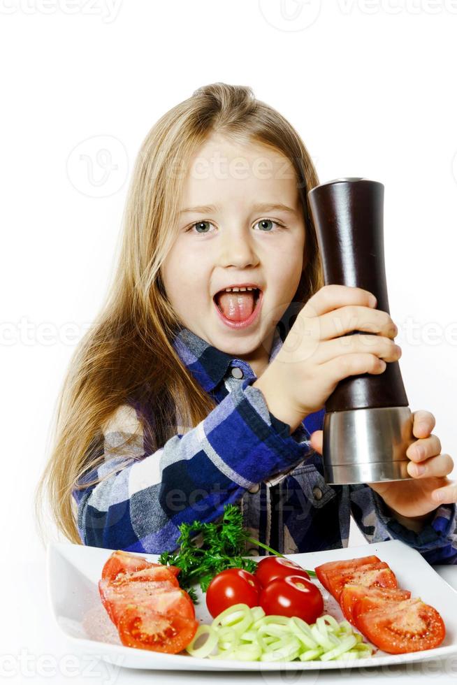 bambina carina con scatola di insalata e pepe foto