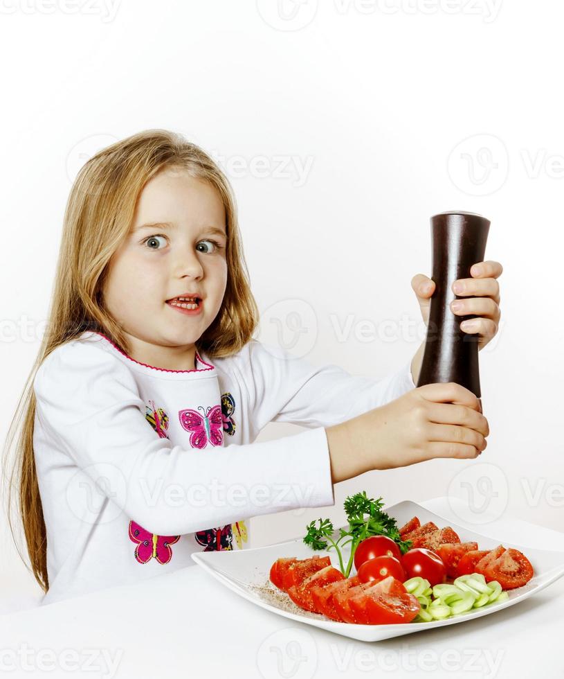 bambina carina con scatola di insalata e pepe foto