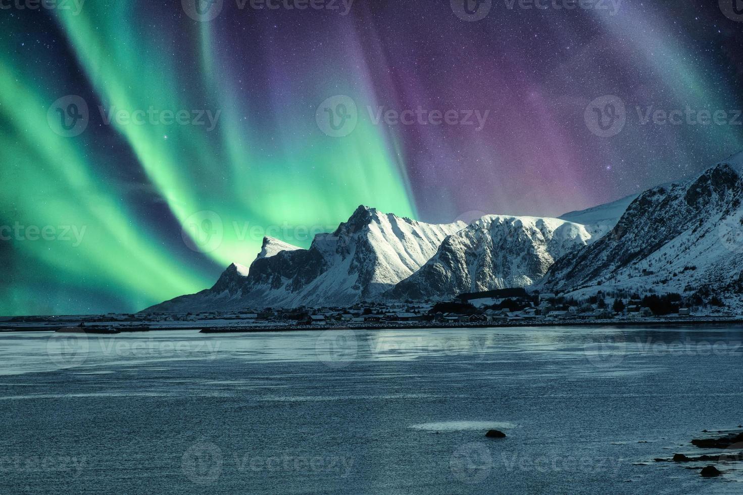 aurora boreale, aurora boreale sopra la montagna innevata nelle isole lofoten foto