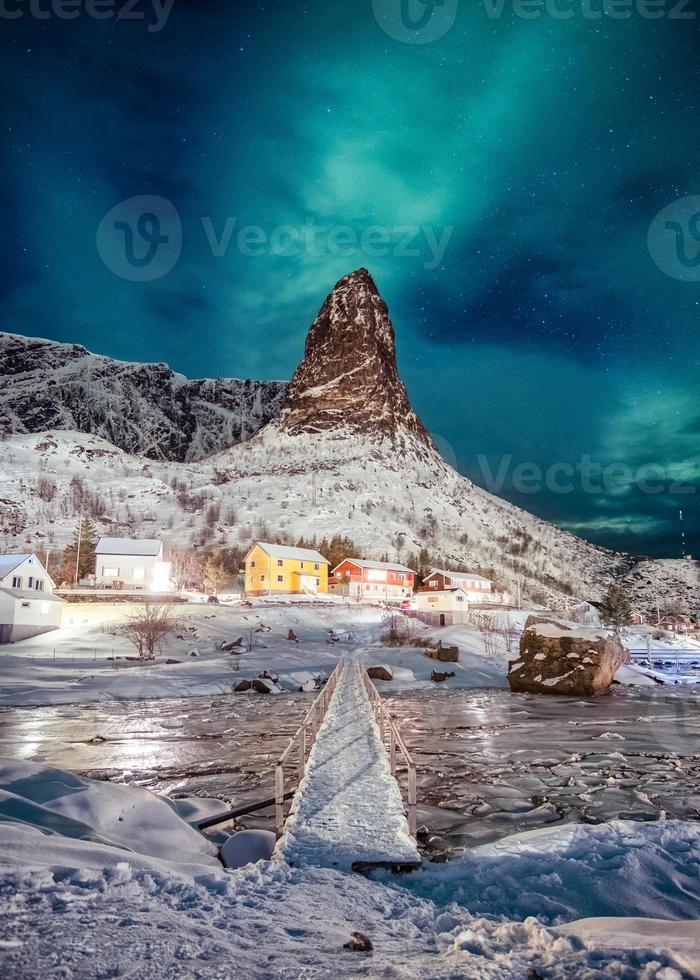 aurora boreale sulla montagna con colori villaggio scandinavo alle lofoten foto