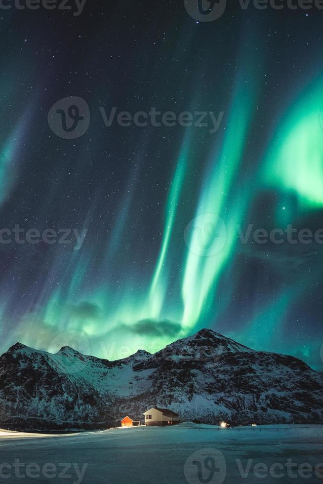 aurora boreale, aurora boreale con stelle che brillano sulla montagna innevata nel cielo notturno in inverno alle isole lofoten foto